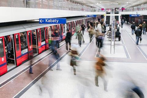 People entering and exiting a subway train at a station.