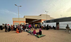 Personas huyendo del conflicto en Sudán en una estación de autobuses de Jartum.