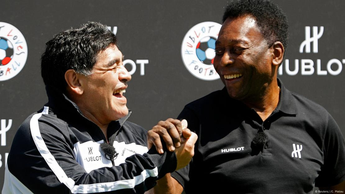 Pelé e Diego Maradona se cumprimentam sorrindo em evento de patrocinador na Eurocopa de 2016, na França