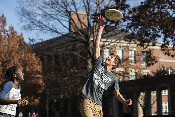 Students playing frisbee on campus