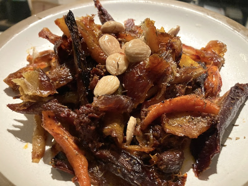 Roasted orange and red carrots with almonds on top.