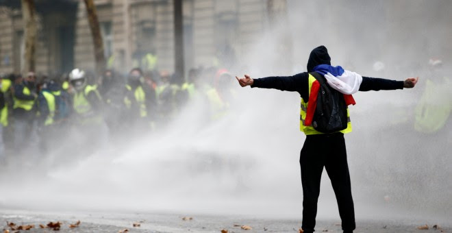 Un manifestante de los chalecos amarillos desafía a los antidisturbios durante las protestas en la Plaza de l'Etoile en París.- Stephane Mahe/REUTERS
