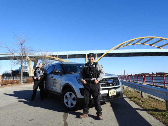 two conservation wardens pose in front of a bridge in Milwaukee