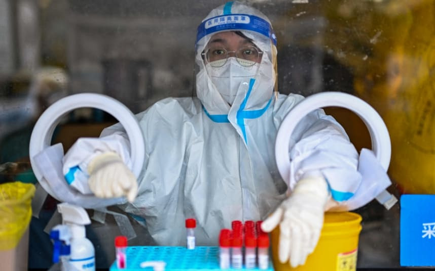 A health worker waits to take Covid swab samples in Shanghai.