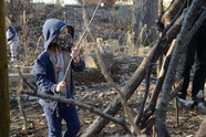 young child building a stick fort