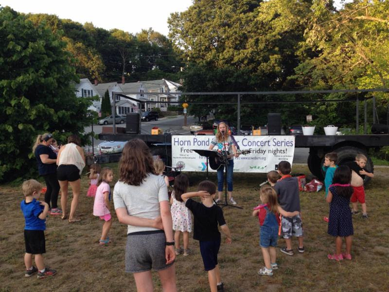 Children dancing and enjoying the summer concert at Horn Pond.