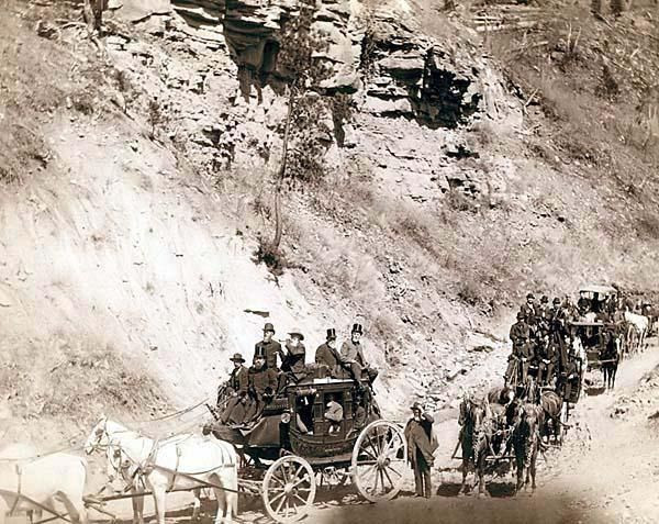 Omaha Board of Trade in Mountains near Deadwood, April 26, 1889. It was created in 1889 by Grabill, John C. H., photographer. The picture presents Procession of stagecoaches loaded with passengers coming down a mountain road.: