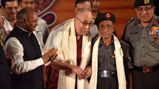 In this photograph taken on 2 April 2017, Tibetan spiritual leader the Dalai Lama (L) shakes hands with retired Assam Rifles personnel Naren Chandra Das