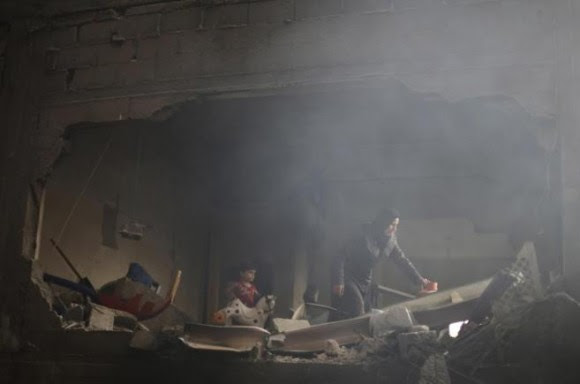 Una mujer palestina rebusca entre los escombros de lo que antes era su casa. Foto: Reuters.