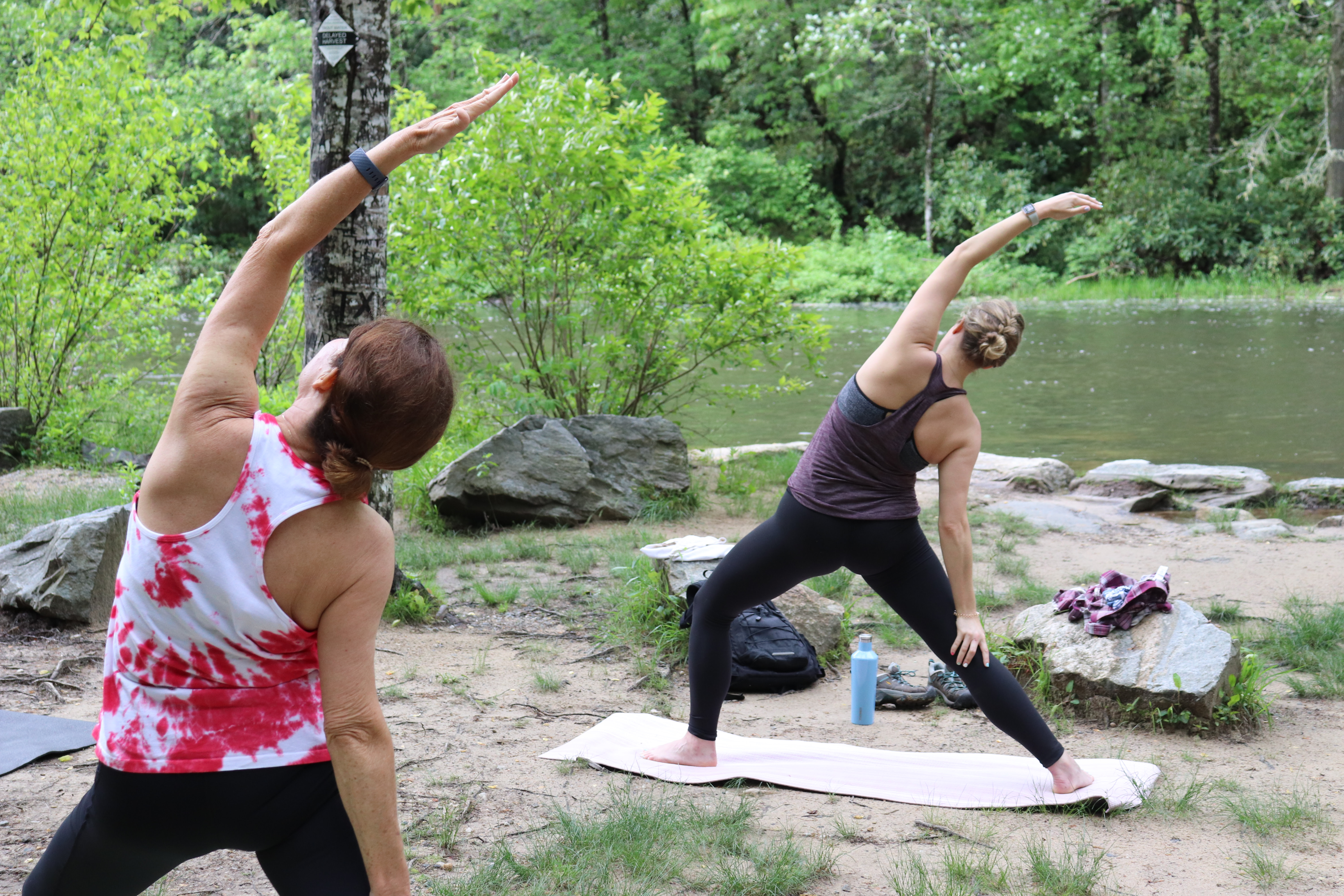 Photo of people practicing yoga my a creek