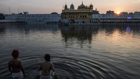 Adhuruesit e Sikhut bëjnë një zhytje në Sarovar (rezervuar uji) i shenjtë gjatë perëndimit të diellit të fundit të vitit 2021 në prag të Vitit të Ri 2022, në Tempullin e Artë të faltores Sikh në Amritsar më 31
dhjetor 2021.