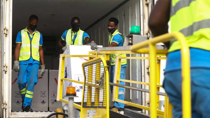 Funcionários do aeroporto descarregam um carregamento de vacinas Covid-19 do programa global de vacinação Covid-19 da Covax, no Aeroporto Internacional de Kotoka em Acra, em 24 de fevereiro de 2021.