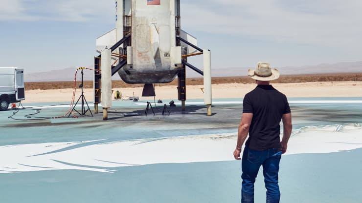Jeff Bezos looks at a rocket booster on the landing pad