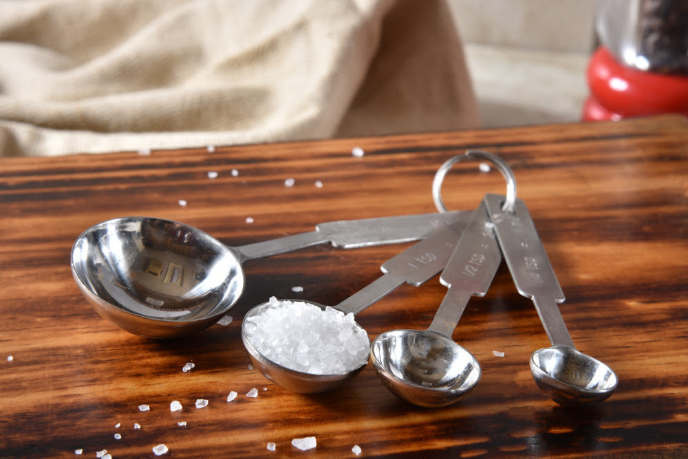 set of measuring spoons with salt in the one teaspoon spoon