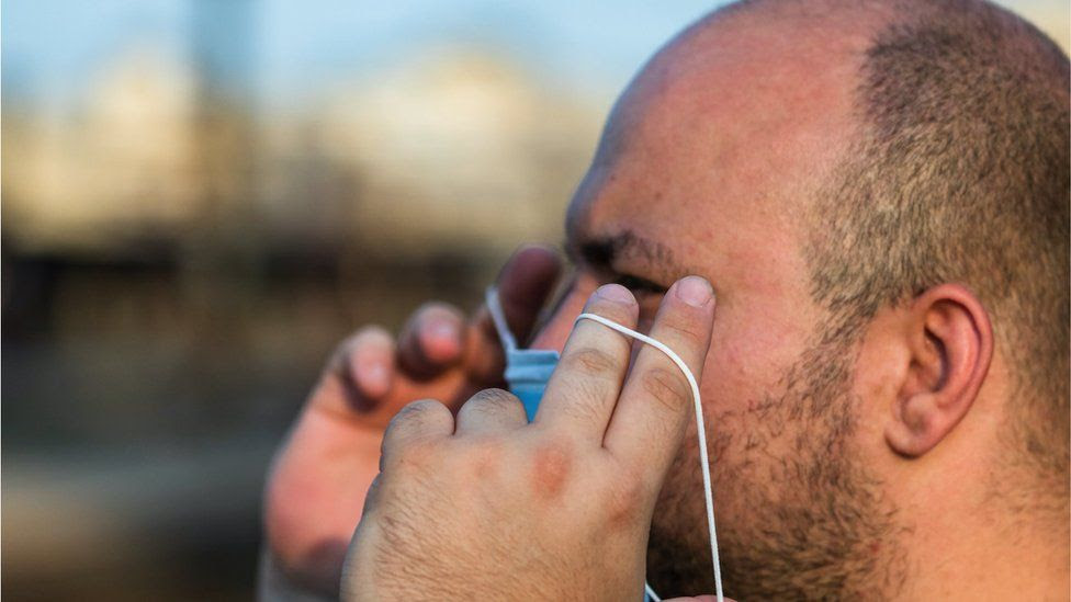 File picture of a man putting on a mask