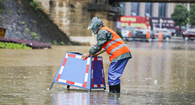 emergency response offical placing warning sign up in flooded street area