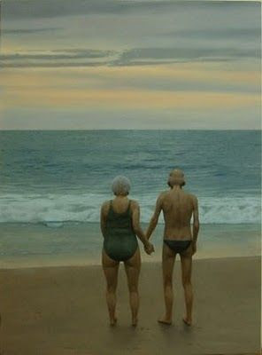 old couple holding hands on the beach: 