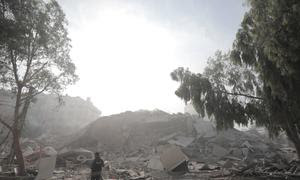 Un hombre mira un edificia destruido por los bombardeos israelíes a Gaza.
