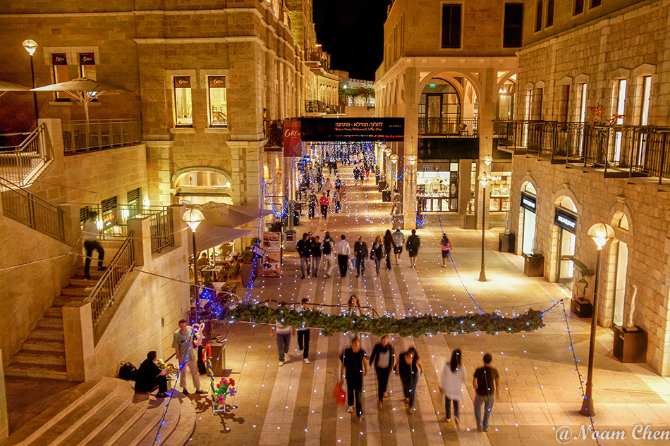 shops and peoople at the decorated mamilla mall in jerusalem at night