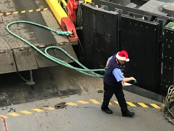 Photo of ferry crewmember working and wearing a Santa hat