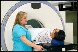 The figure above is a photograph showing a health care provider perform a scan on a patient.