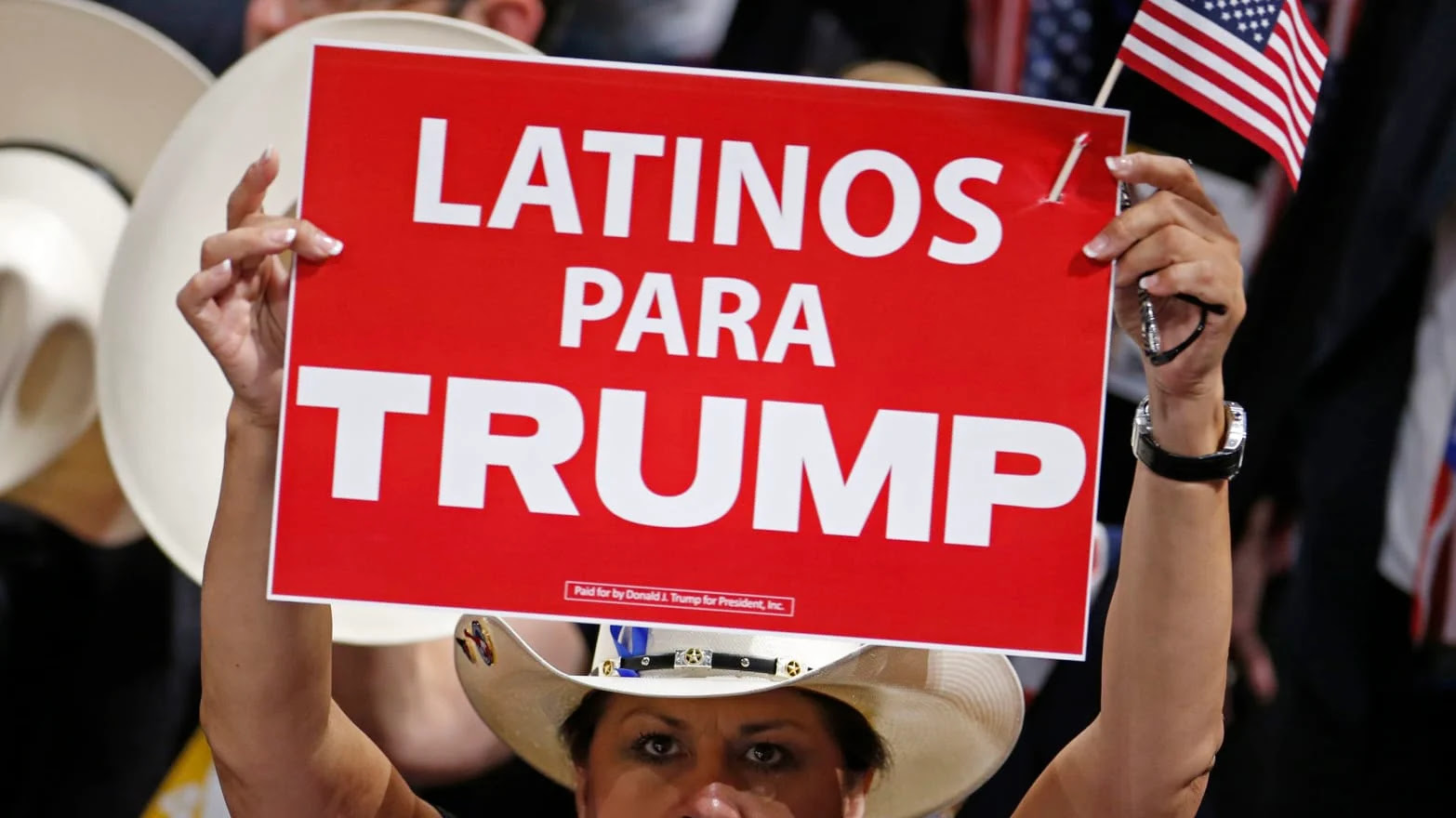 A woman at a rally for Trump holding a sign reading ''Latinos Para Trump''