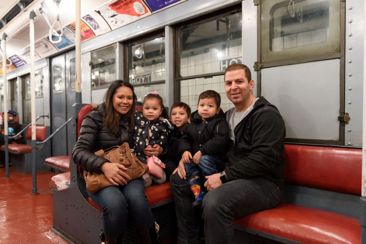 Family on vintage R1/9 train car at the New York Transit Museum 