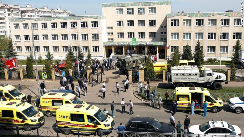 Multiple ambulances and police vehicles are seen outside of the Russian school where the shooting took place