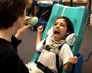 Child with large smile and arms spread wide when adult shows squishy toy