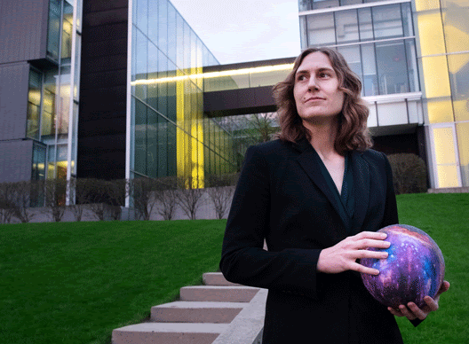 Image of Katie Mack holding a sphere.