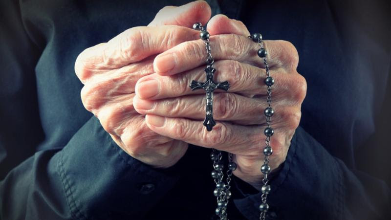 elder_woman_holding_rosary.jpg