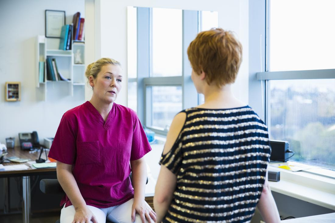 female doctor speaking in office to female patient