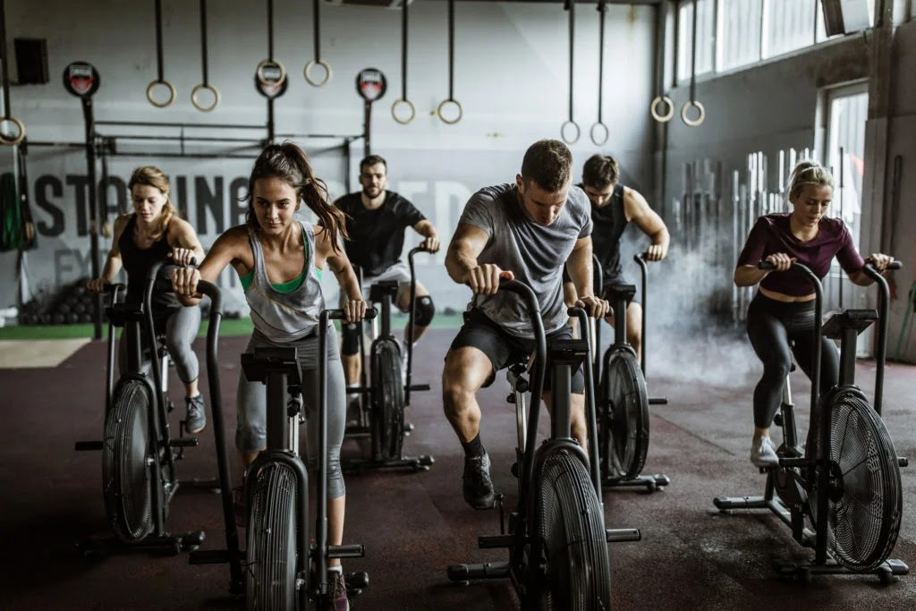 Men and women on exercise bikes