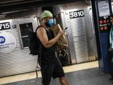 A commuter wears a face mask in the New York City transit system, Monday, March 9, 2020, in New York. New York continued grappling Monday with the new coronavirus, as case numbers, school closings and other consequences grew. (AP Photo/John Minchillo)