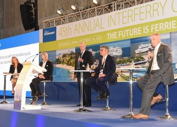 Photo of four people sitting on stage during a conference panel session