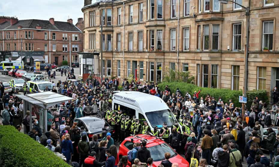 Protesters block the immigration enforcement van on Kenmure Street in Glasgow