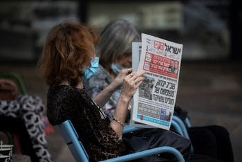 A woman reads Israel Hayom in Ramat Gan, October 14, 2020.