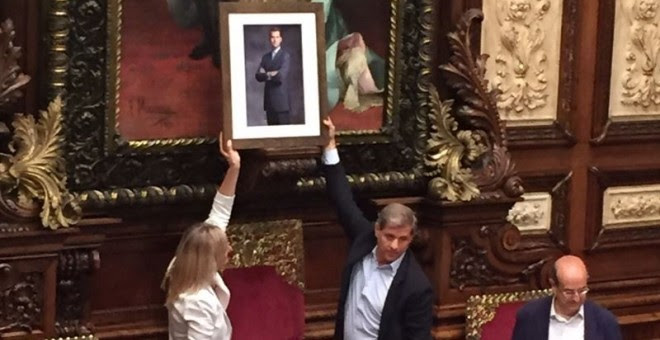Momento en el que Fernández y Esteller colocan la fotografía de Felipe VI en el salón de plenos del Ayuntamiento de Barcelona.