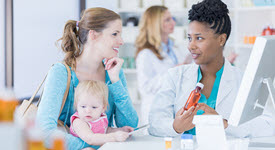 Mom with child speaking to pharmacist