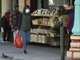 A masked shopper walks in the Chinatown district of San Francisco on Friday, Jan. 31, 2020. As China grapples with the growing coronavirus outbreak, Chinese people in California are encountering a cultural disconnect as they brace for a possible spread of the virus in their adopted homeland. (AP Photo/Ben Margot)