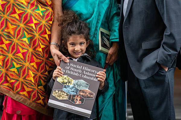 Close-up image of little girl holding a book.
