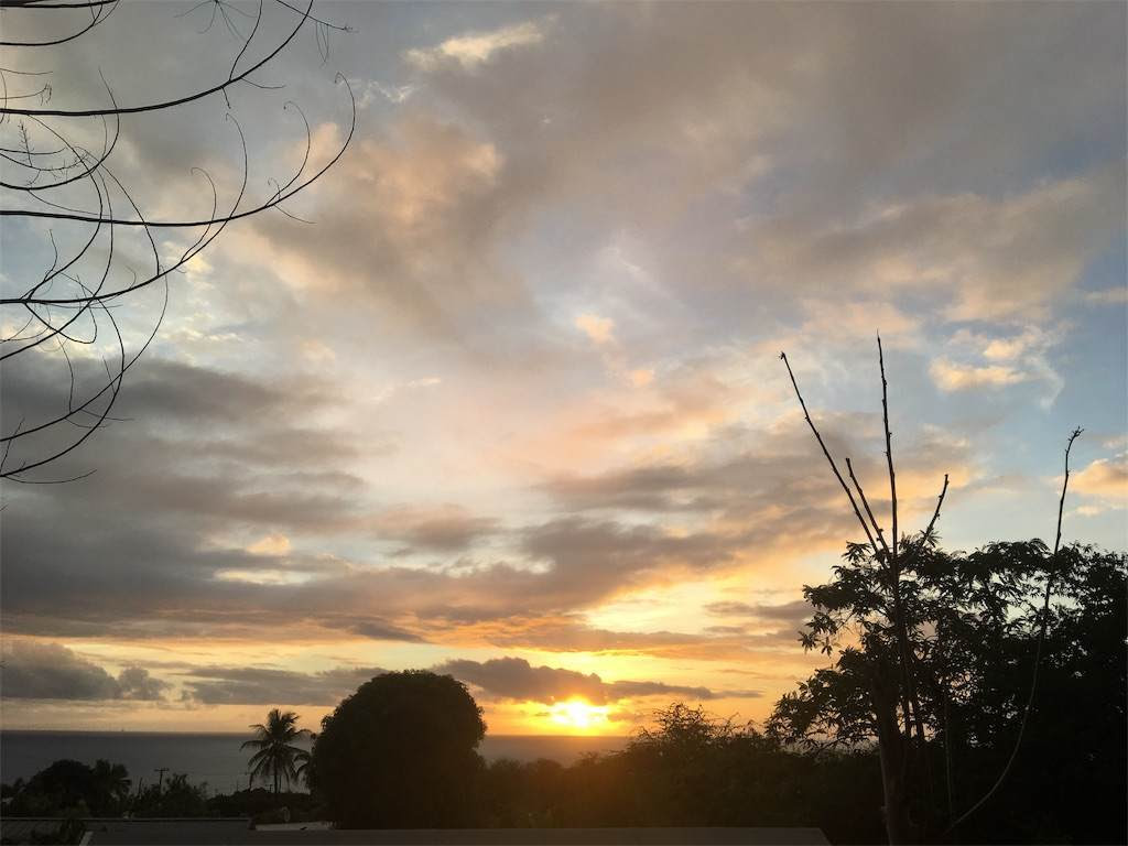同じ視界の夕焼け。雲の間から夕陽の光が差し込む。