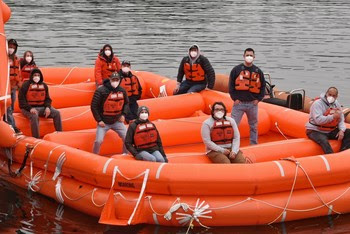 Photo of new crewmembers posing for a photo in a rescue boat