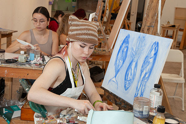 Students painting in studio classroom.
