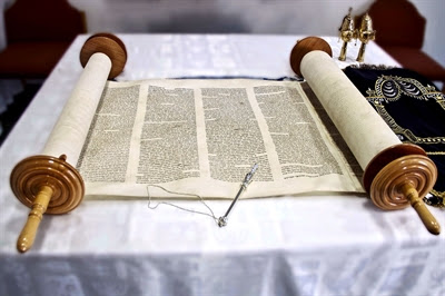 Open Torah scroll and silver
                  yad (Torah pointer)