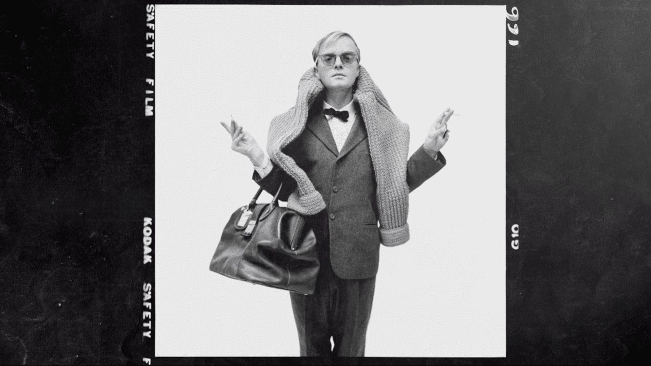 Truman Capote in a suit with a leather carryall