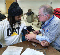 MRC Volunteer taking a persons blood pressure