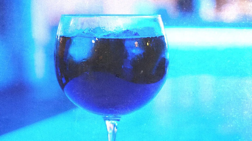 Glass of red wine recolored to look purple