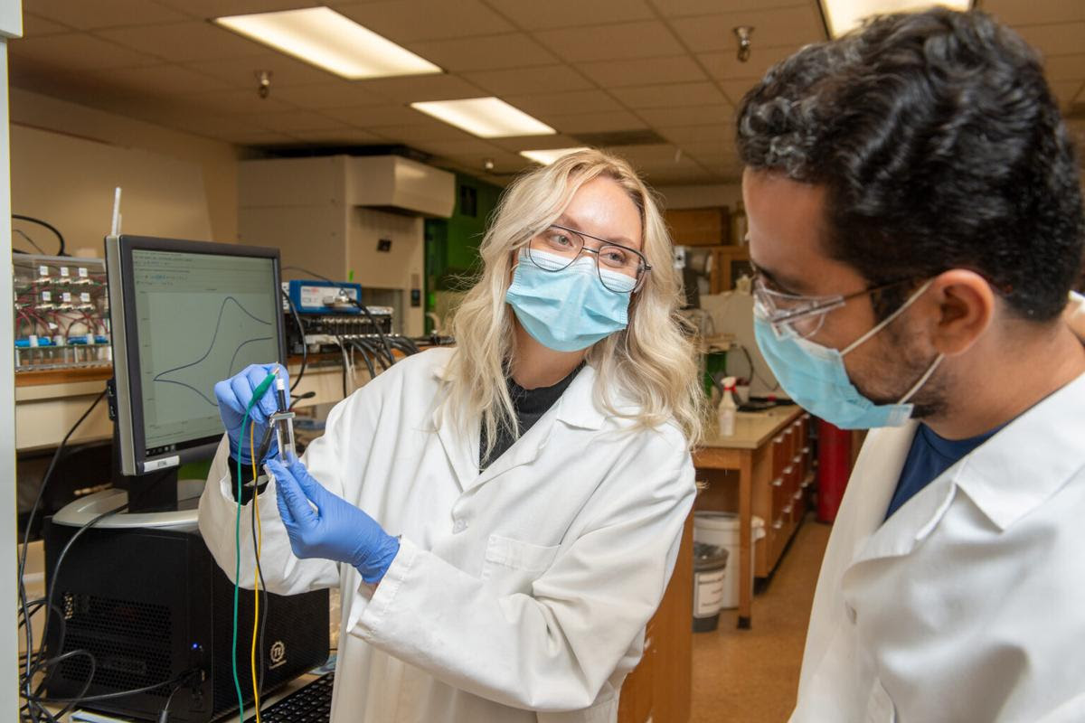 Postdoctoral researcher Abdelrhman Mohamed (right) observes as graduate student Gretchen Tibbitts uses an electronic probe to measure bacterial electrochemical signals