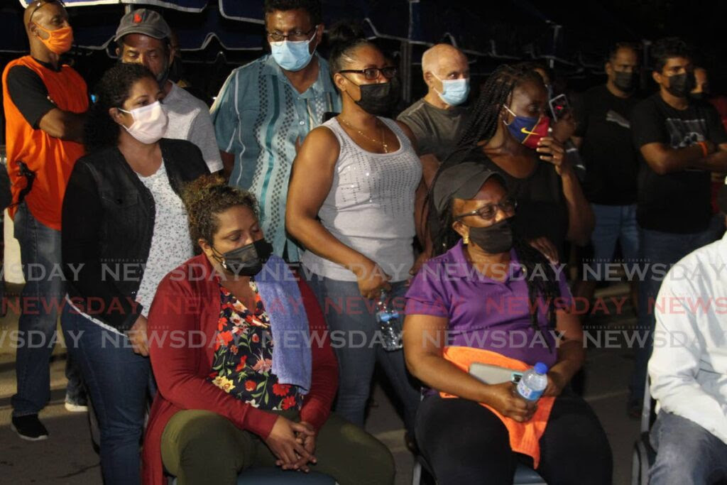 Heartbroken relatives and friends of divers Kazim Ali, Yusuf Henry, Rishi Nagassar and Fyzal Kurban sit in the carpark outside Heritage Petroleum in Pointe-a-Pierre on Sunday. after being told that the rescue operation has been turned into a recovery operation. - Marvin Hamilton